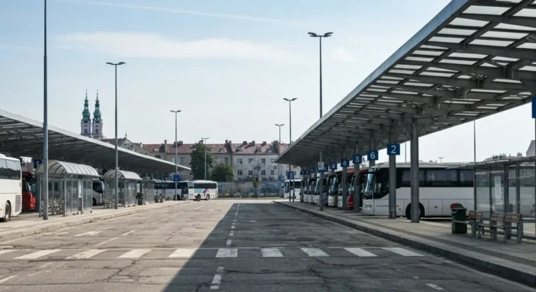 Regionalny dworzec autobusowy w Czestochowie z peronami i autobusami, w tle wieza Jasnej Gory.